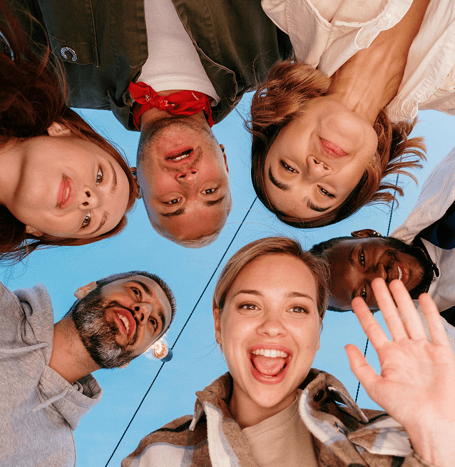 Circular group photo showcasing a diverse mix of smiling individuals of various ages and ethnicities, looking at the camera.